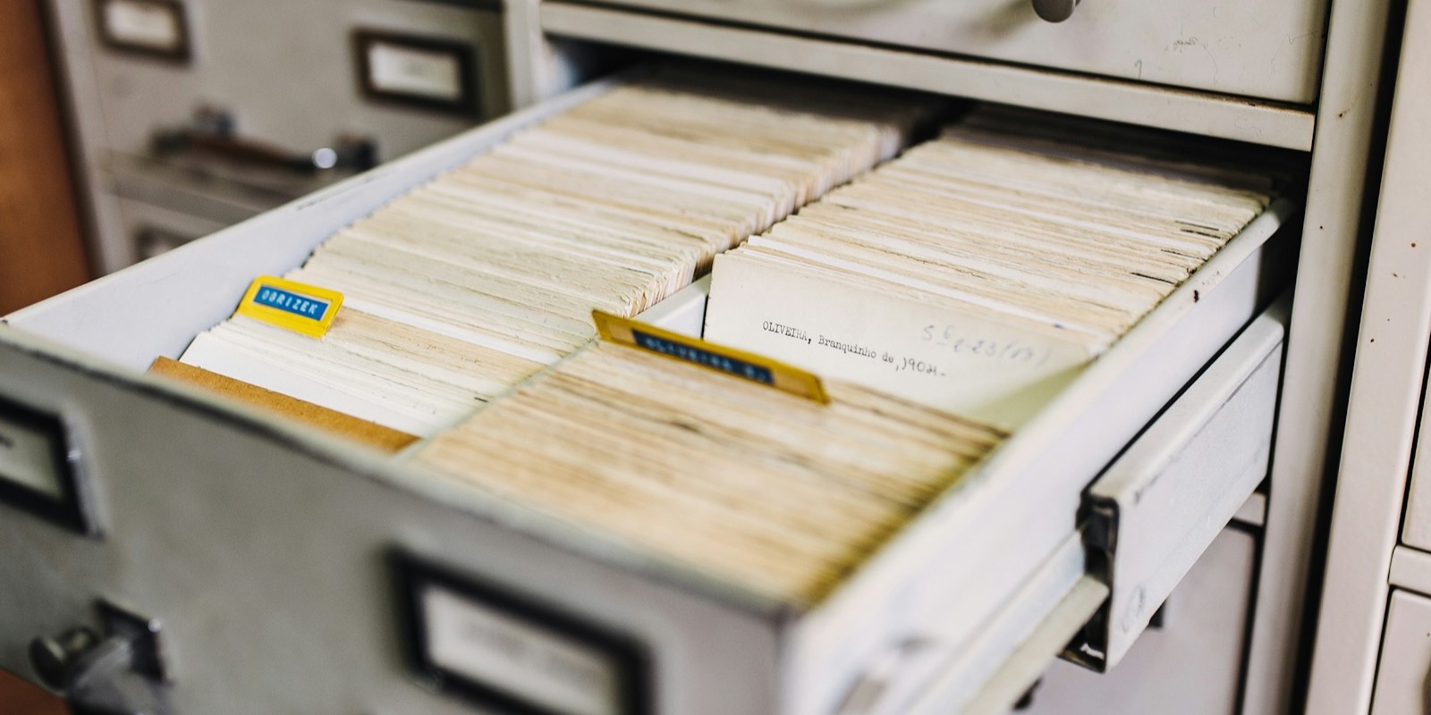 An open archive drawer packed with filed index cards